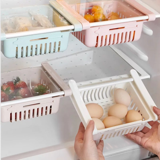 Adjustable Hanging Storage Baskets for Refrigerator Four rectangular hanging storage baskets inside a refrigerator. The baskets are pastel colors: light blue, pink, beige, and white. Each basket has vertical slits on the sides and bottom. The baskets are attached to white adjustable rails. The white basket
