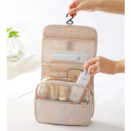 Beige hanging travel toiletry organizer with multiple mesh and clear compartments for personal care items
