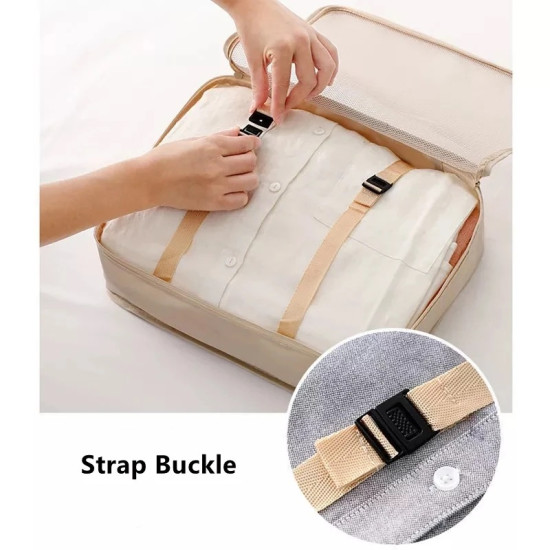 Beige travel packing cube with strap buckle securing folded clothes inside a suitcase organizer