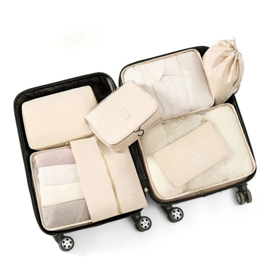 Beige travel packing cubes set with eight pieces neatly organized inside an open black suitcase
