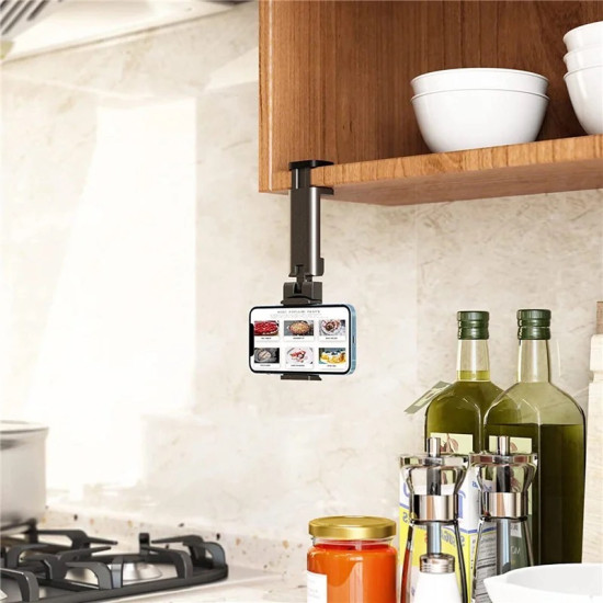 Black adjustable phone holder clamped under wooden kitchen cabinet holding a smartphone horizontally
