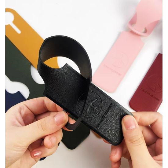 Black flexible luggage tag with embossed circular logo and loop for attaching to bags
