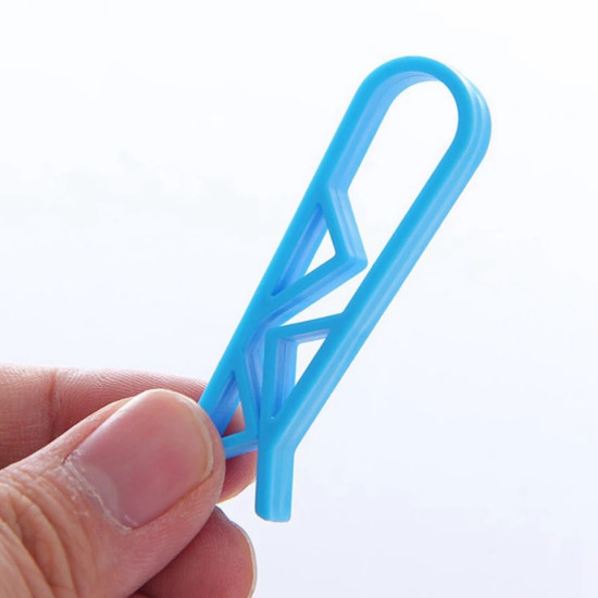 Blue plastic clip with geometric cutouts held between fingers, used to secure trash bags