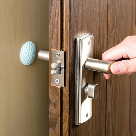 Blue textured rubber door bumper pad attached to wall behind door handle to reduce impact