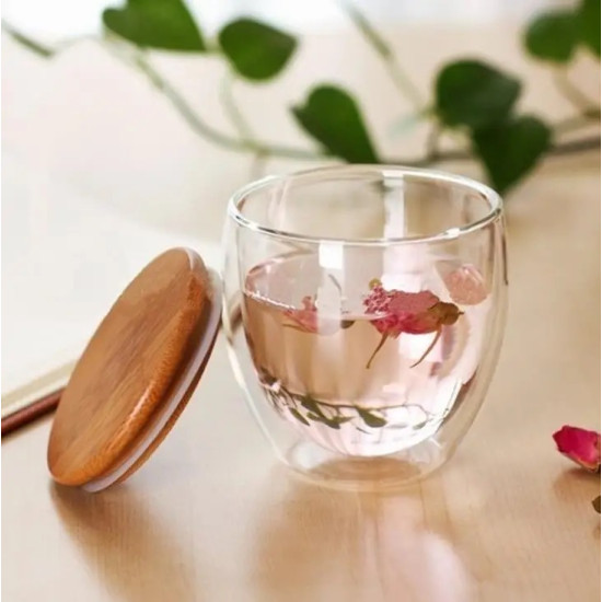 Clear Double Wall Glass Cup with Bamboo Lid for Heat Retention Clear double wall glass cup filled with pink flower tea next to a round bamboo lid on a light wooden surface