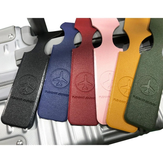 Colorful leather luggage tags embossed with airplane logo and 'PLEASANT JOURNEY' text attached to silver suitcase handle