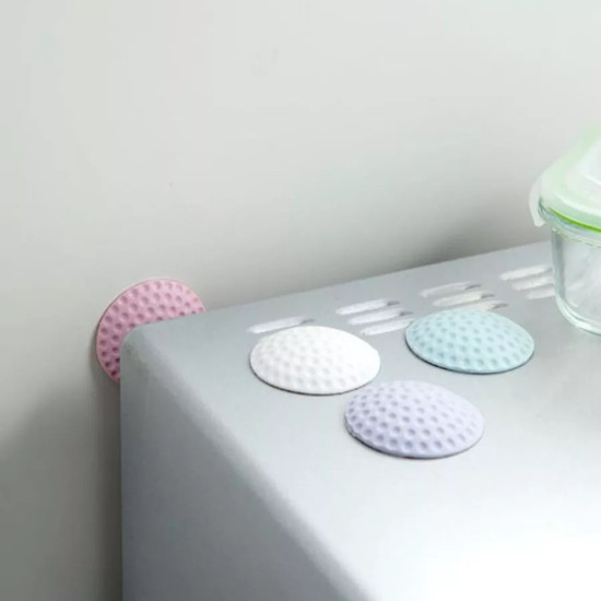Colorful round textured rubber shock absorber pads attached to a surface and wall corner