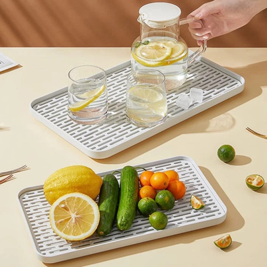 Double Layer Spill-Proof Serving Tray Double-layer white serving tray with slotted surface holding glass pitcher, glasses, and assorted fruits