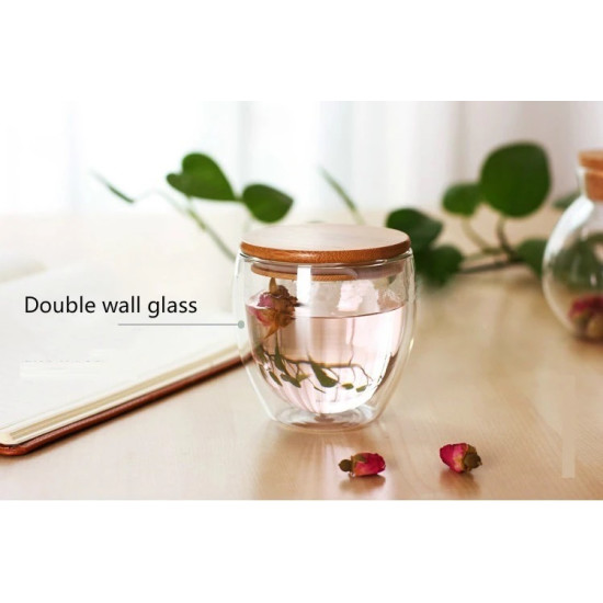 Double Wall Glass Cup with Bamboo Lid for Beverage Heat Retention Double wall glass cup with round bamboo lid filled with light pink flower tea on wooden surface