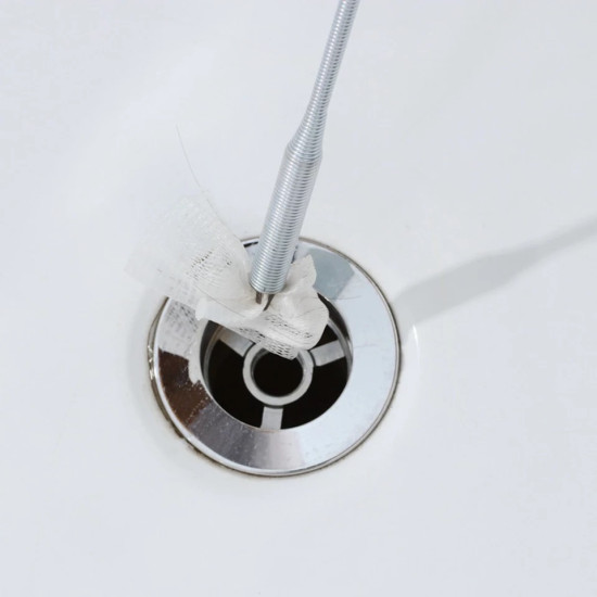 Flexible Metal Spring Tool for Grabbing Items in Narrow Spaces Flexible metal spring tool grabbing a white net piece from a drain