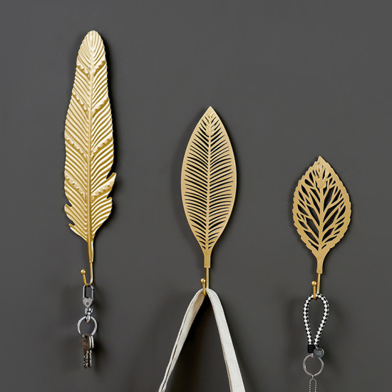 Set of three golden metal leaf-shaped wall hooks with different embossed and cutout vein patterns