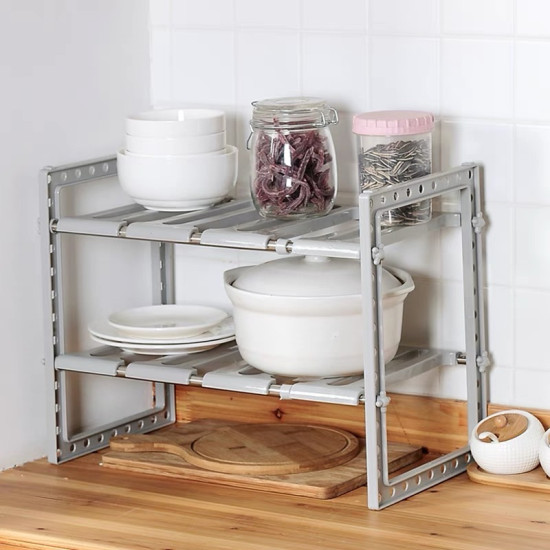 Gray Expandable Kitchen Shelf with White Dishes and Jars Gray expandable kitchen shelf holding white bowls, plates, a pot, and jars with food items