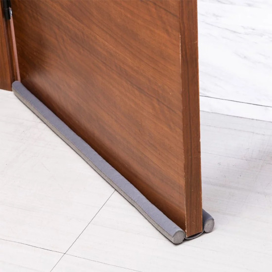 Gray Foam Draft Stopper for Door Bottom Gray foam draft stopper placed under a wooden door to block air, dust, and insects