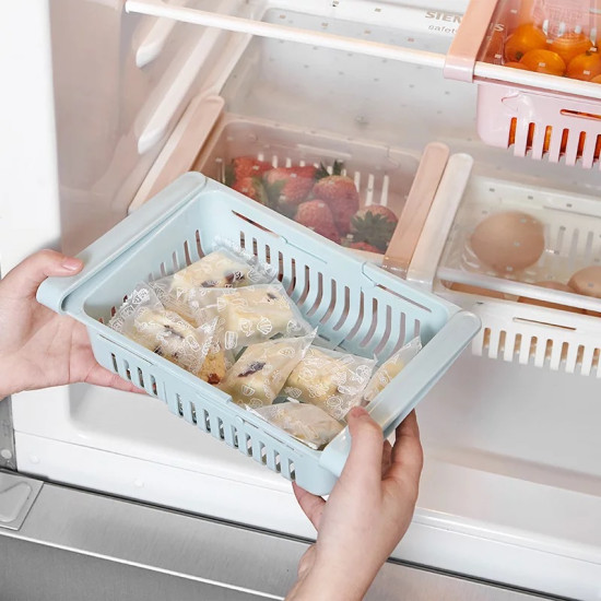 Light Blue Rectangular Storage Basket with Handles and Vertical Slits Light blue rectangular storage basket with vertical slits on the sides and bottom. The basket has two thick horizontal handles on the shorter sides. It is held by two hands inside a refrigerator. Inside the basket, there are several individually wrapped f