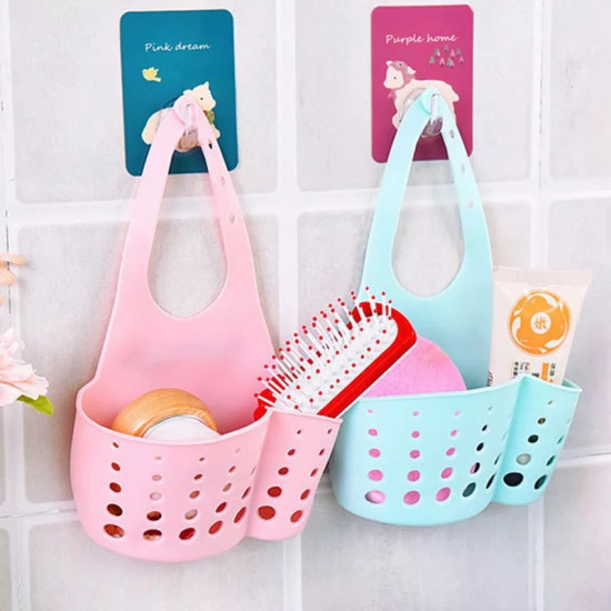 Pink and blue silicone holders with holes hanging on wall hooks, storing bathroom and kitchen items