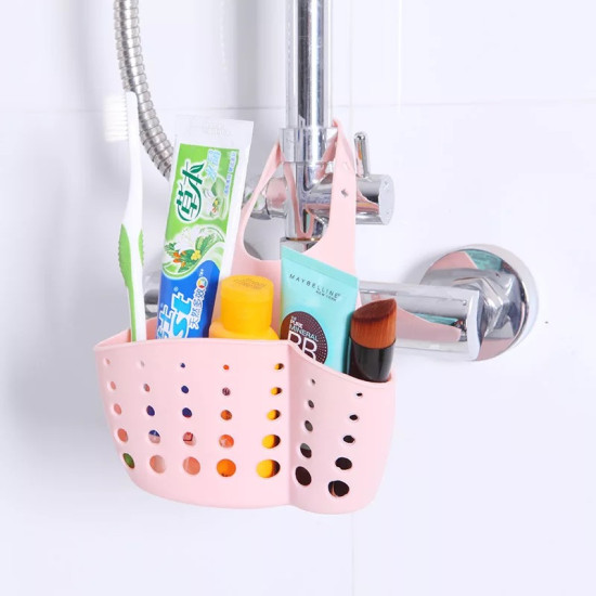 Pink silicone holder with multiple holes hanging on bathroom faucet holding toothbrush and toiletries