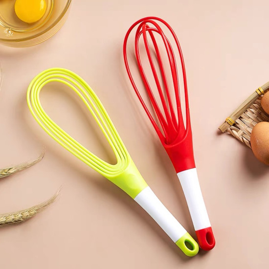 Red and yellow silicone hand whisks with white handles and hanging holes on beige surface