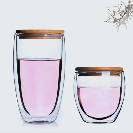 Double Wall Glass Cups with Bamboo Lids - Set of Two Different Sizes Two clear double wall glass cups of different sizes filled with pink liquid, each with a round bamboo lid