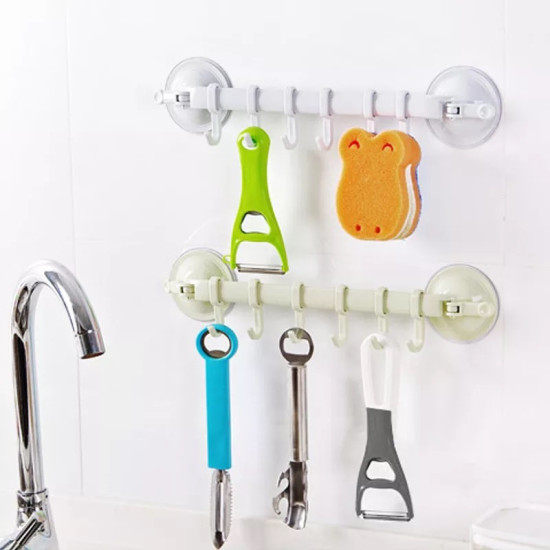 Multi-use No-Drill Hook Bars for Kitchen and Bathroom Two suction cup hook bars mounted on white tiled wall holding kitchen tools and sponge