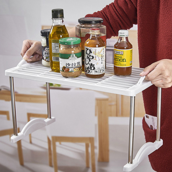 White multi-layer storage rack with metal legs holding various bottles and jars