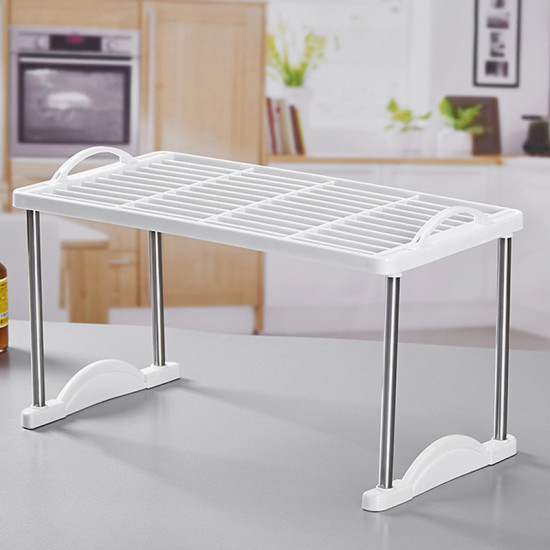 White plastic and metal kitchen storage shelf with handles and grid surface for organizing items