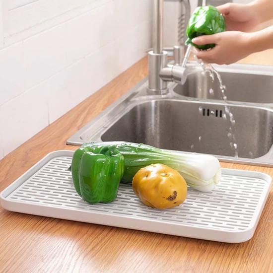 Double Layer Spill-Proof Serving Tray White rectangular draining tray with vented surface holding vegetables on wooden countertop